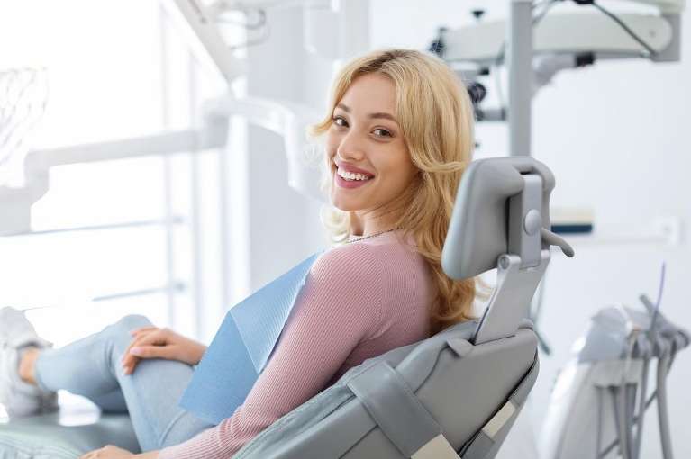 woman with blonde hair sitting in a dental chair